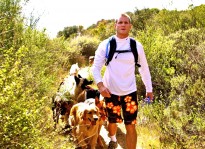 Colin West and his dog pack hiking on the back of a mountain in Spring.