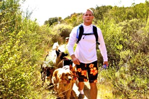 Colin West and his dog pack hiking on the back of a mountain in Spring.